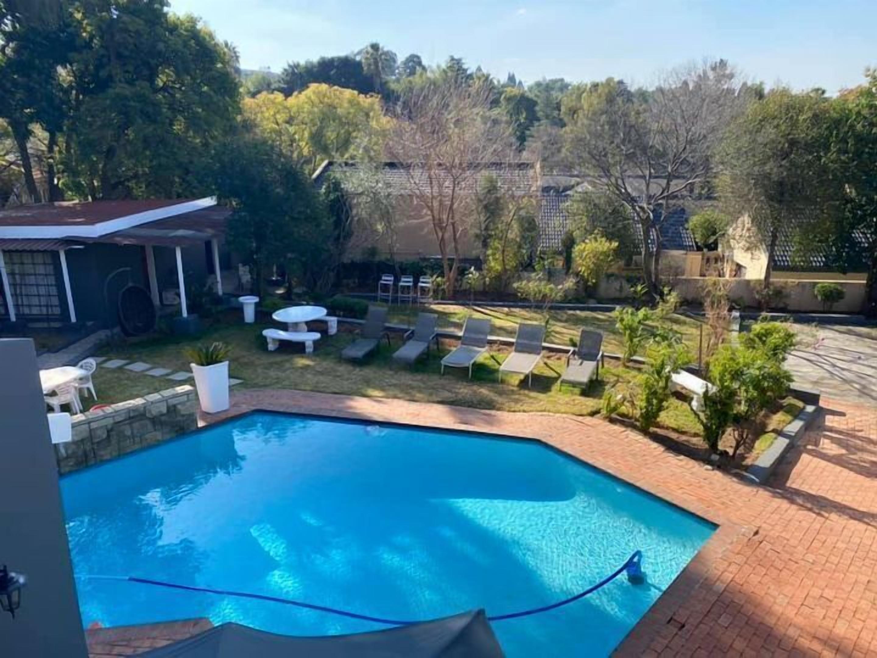 Una piscina con sillas de descanso y un área de patio.