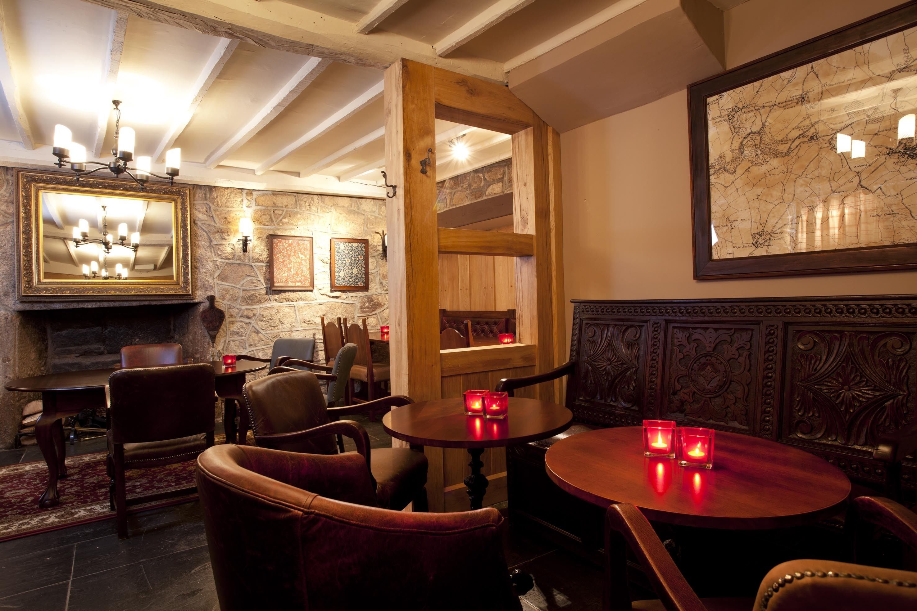 A cozy dining area with wooden furniture, a stone wall, and a large map on the wall.