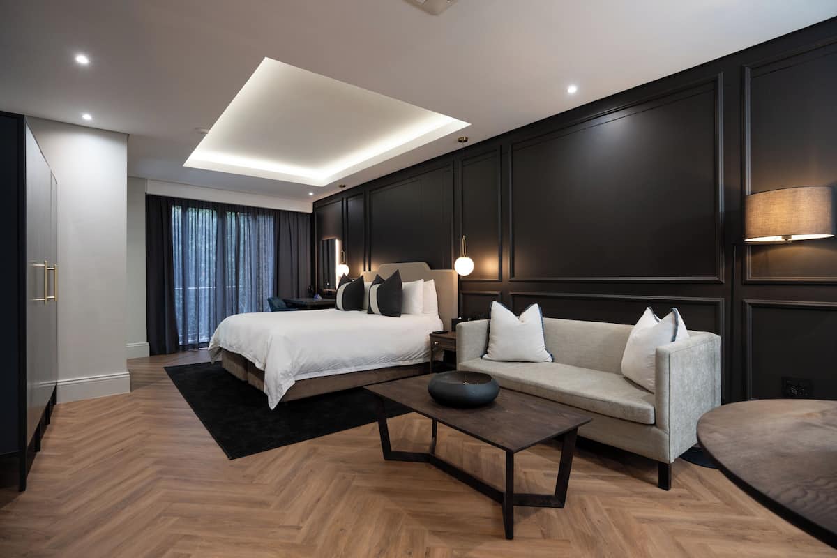 Een moderne hotelkamer met een groot bed, een bank, een salontafel en een bureau.