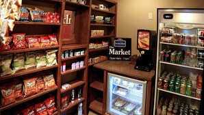 A snack and beverage display in a hotel lobby with various chips, snacks, and drinks.