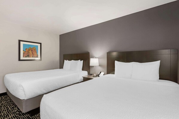 A hotel room with two beds, a nightstand with a lamp, and a framed picture on the wall. - Best Western Plus Sun Canyon (Sierra Vista)