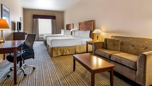A hotel room with two beds, a sofa, a desk, and a chair. - Quality Inn & Suites Rimbey (Rimbey)