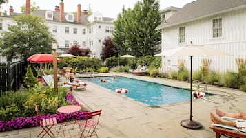 Una piscina al aire libre, sillones reclinables de piscina
