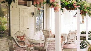 A covered porch with wicker furniture and hanging flower baskets. - The Red Lion Inn (Stockbridge)