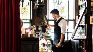 A bar with wooden floors and shelves filled with bottles. - The Red Lion Inn (Stockbridge)