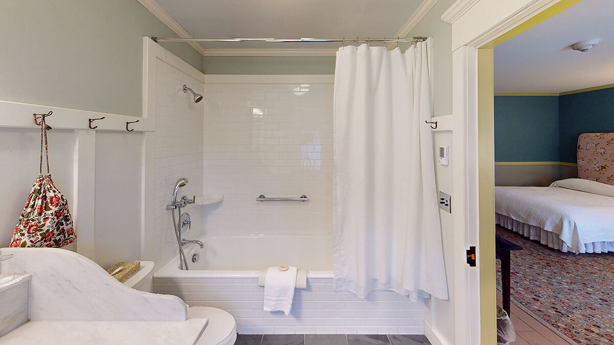 Un baño con bañera, inodoro y ducha.