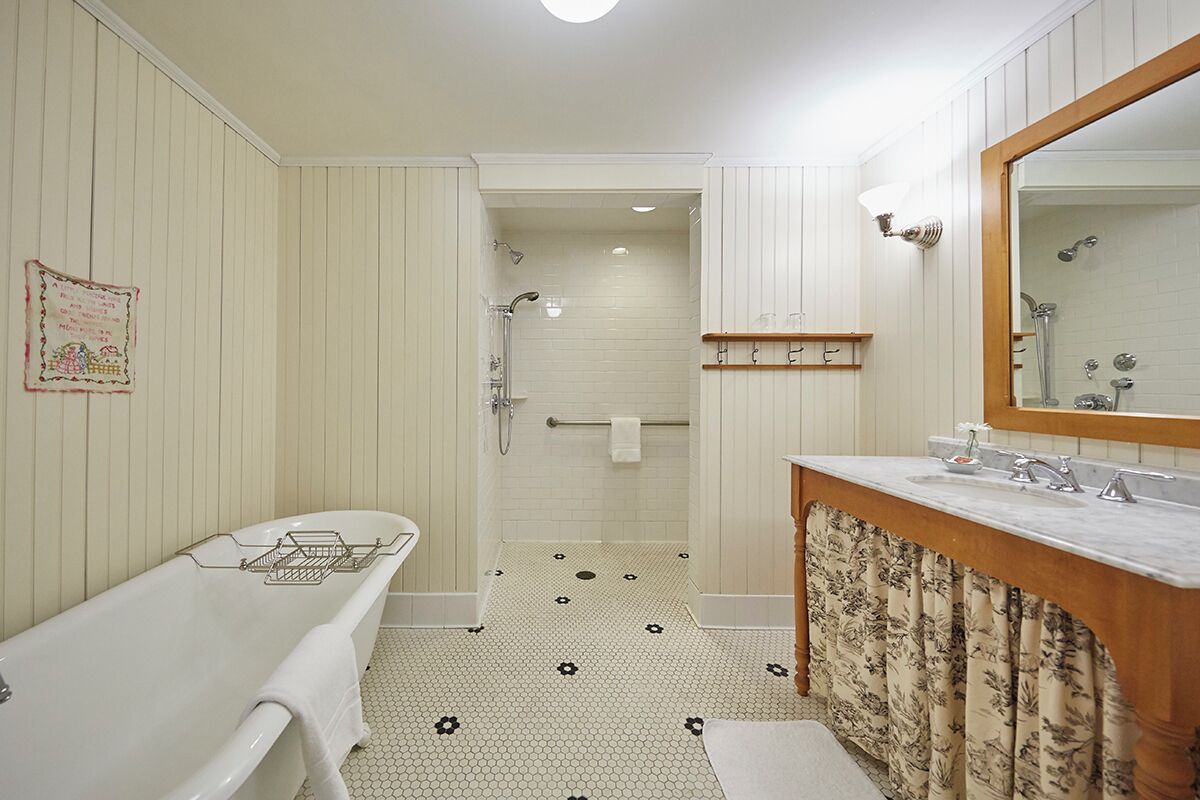 Un baño con bañera, ducha, lavabo y espejo.