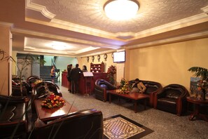 A lobby with leather seating, a reception desk, and a staircase. - Haimi Apartment Hotel (Addis Ababa)