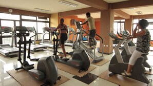 A gym with treadmills, elliptical machines, and a mirrored wall. - Haimi Apartment Hotel (Addis Ababa)