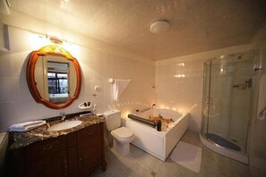 A modern bathroom with a marble sink, a freestanding bathtub, a glass-enclosed shower, and a large mirror with an ornate frame. - Haimi Apartment Hotel (Addis Ababa)