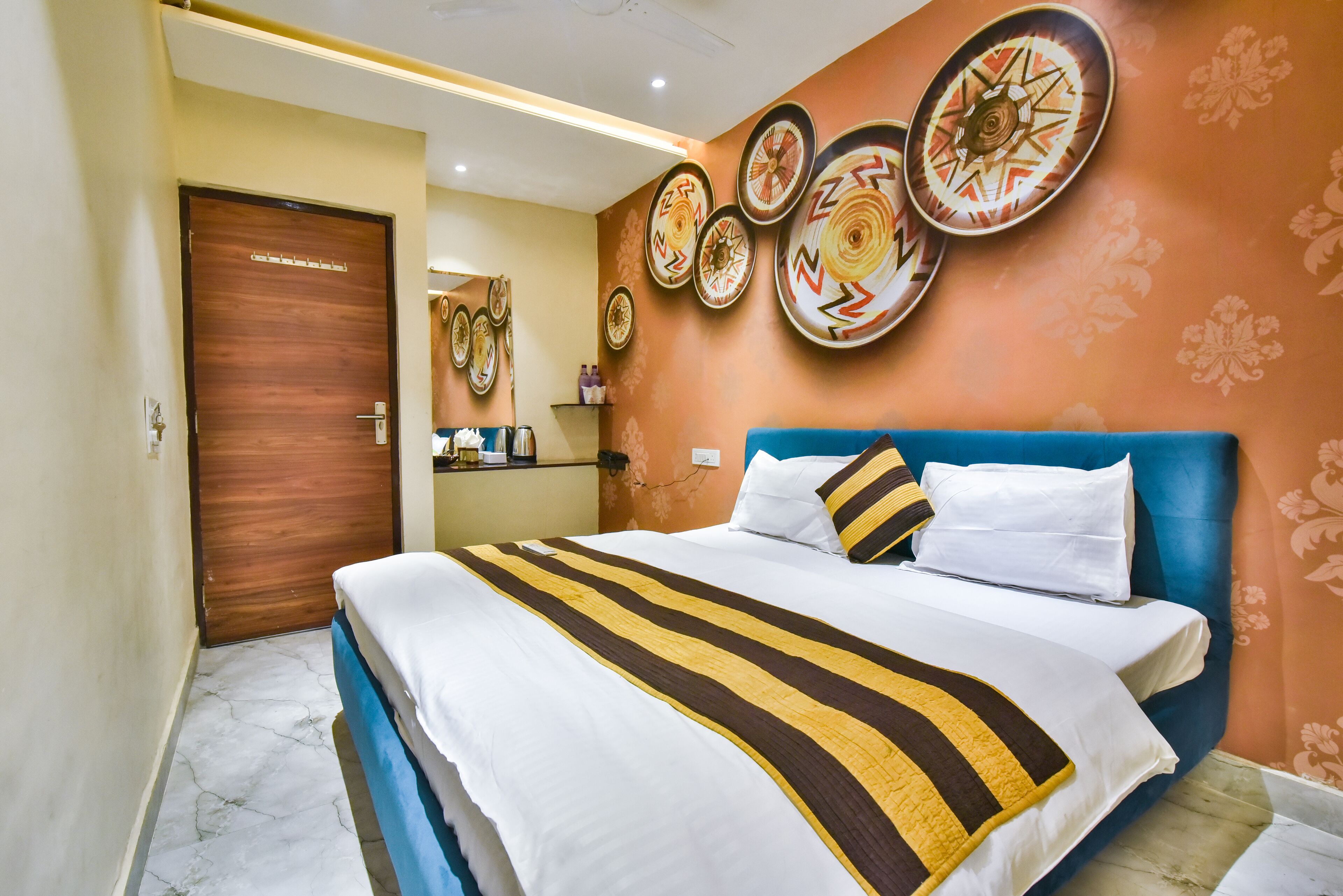 Een hotelkamer met een bed, een houten deur en decoraties aan de muur.