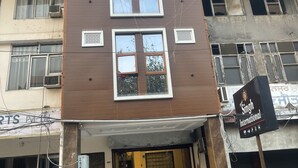 Un edificio a più piani con ingresso a livello strada, condizionatori d'aria e un frigorifero Coca-Cola.