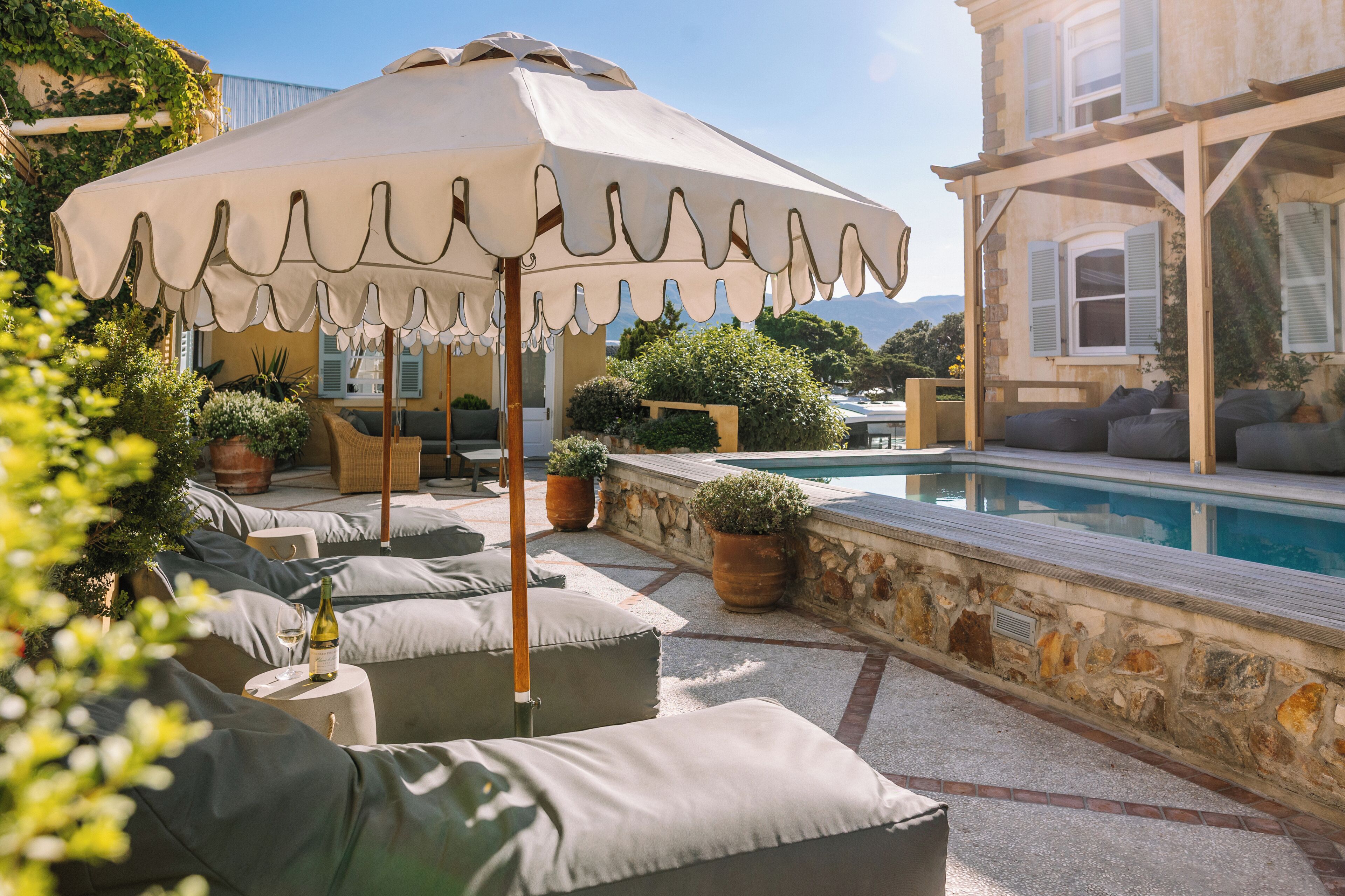 A poolside area with outdoor seating and a large umbrella.