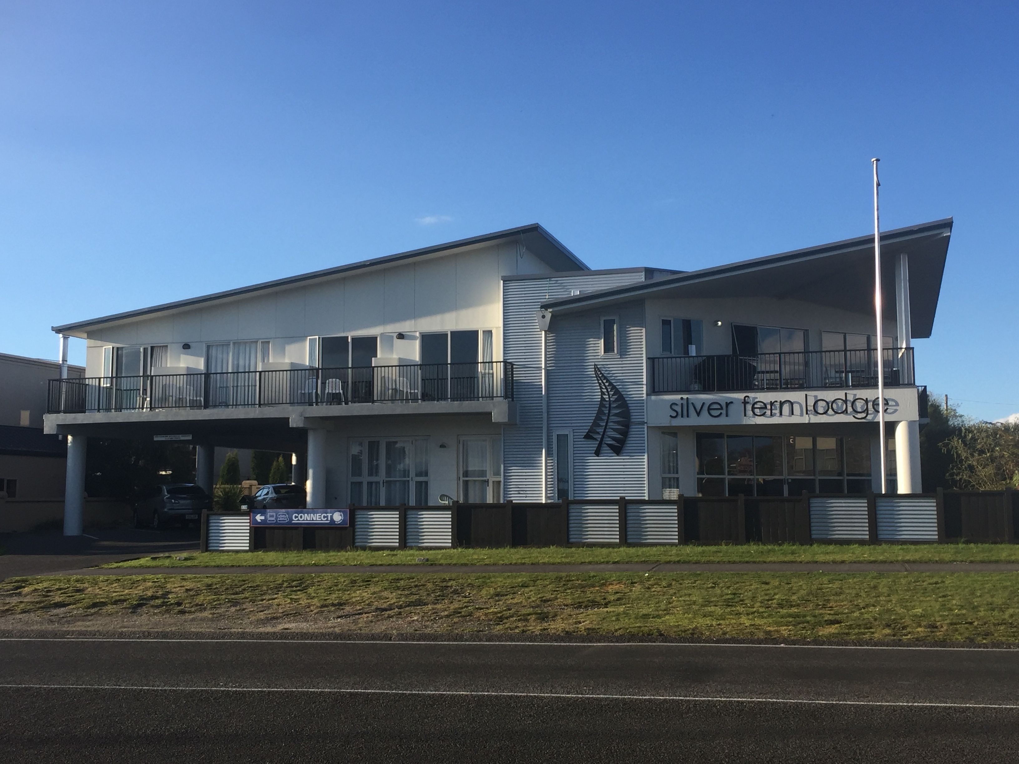Un edificio de dos plantas con un cartel que dice "silver fern lodge".