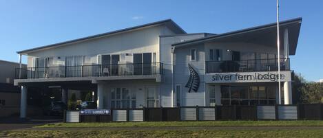 Un edificio de dos plantas con un cartel que dice "silver fern lodge".