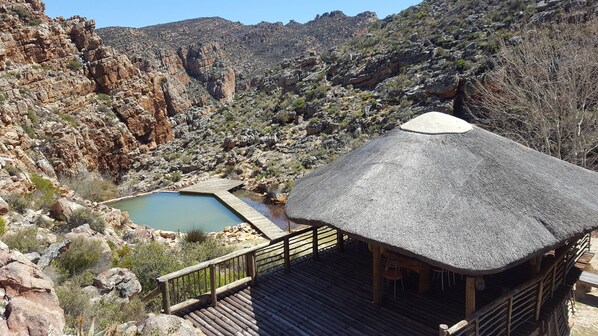 2 buitenzwembaden, een zwemvijver en parasols bij het zwembad