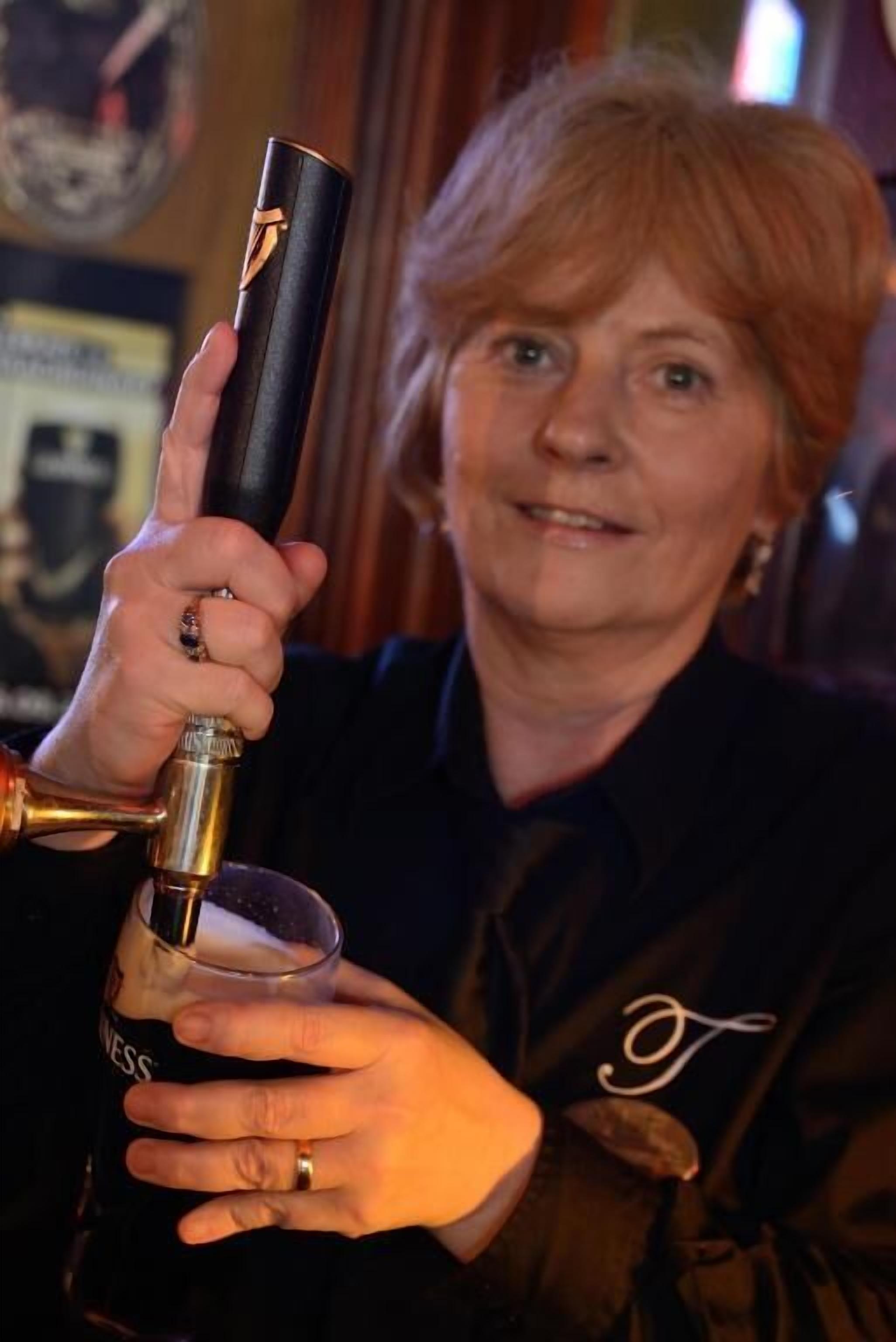 Iemand houdt een glas met een biertap vast.