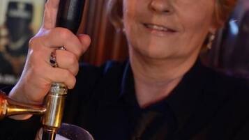 Iemand houdt een glas met een biertap vast.