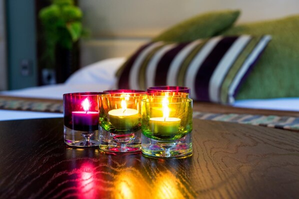 Three lit candles in glass holders on a wooden table.