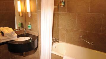 A bathroom with a black sink, a mirror, a bathtub, and a shower curtain.