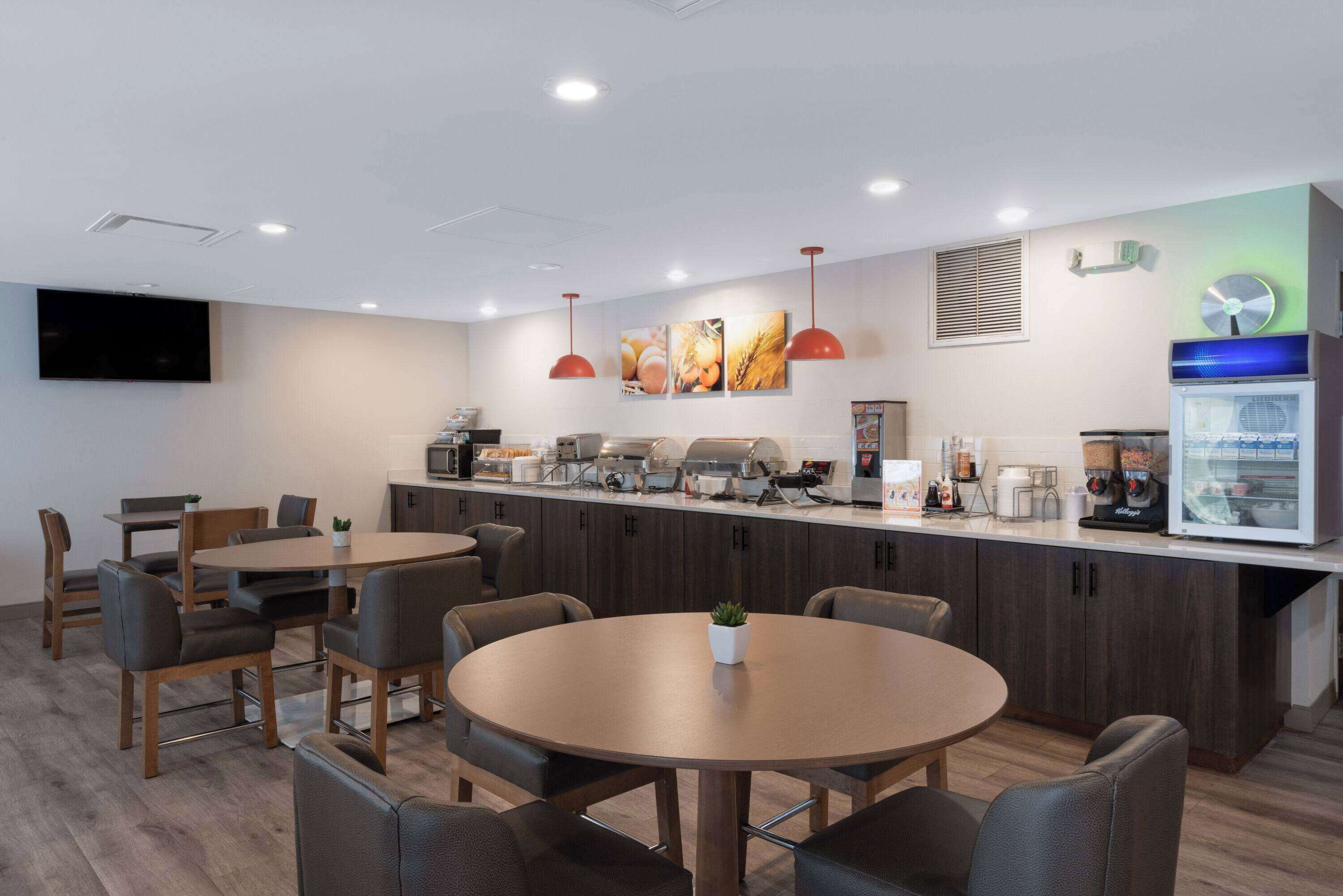 A modern kitchen with a central island, built-in appliances, and pendant lighting.