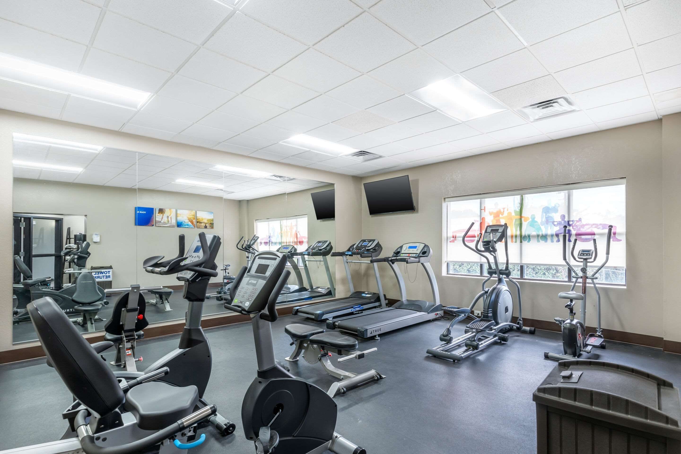 A gym with treadmills, elliptical machines, and weight equipment.