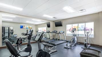 A gym with treadmills, elliptical machines, and weight equipment.