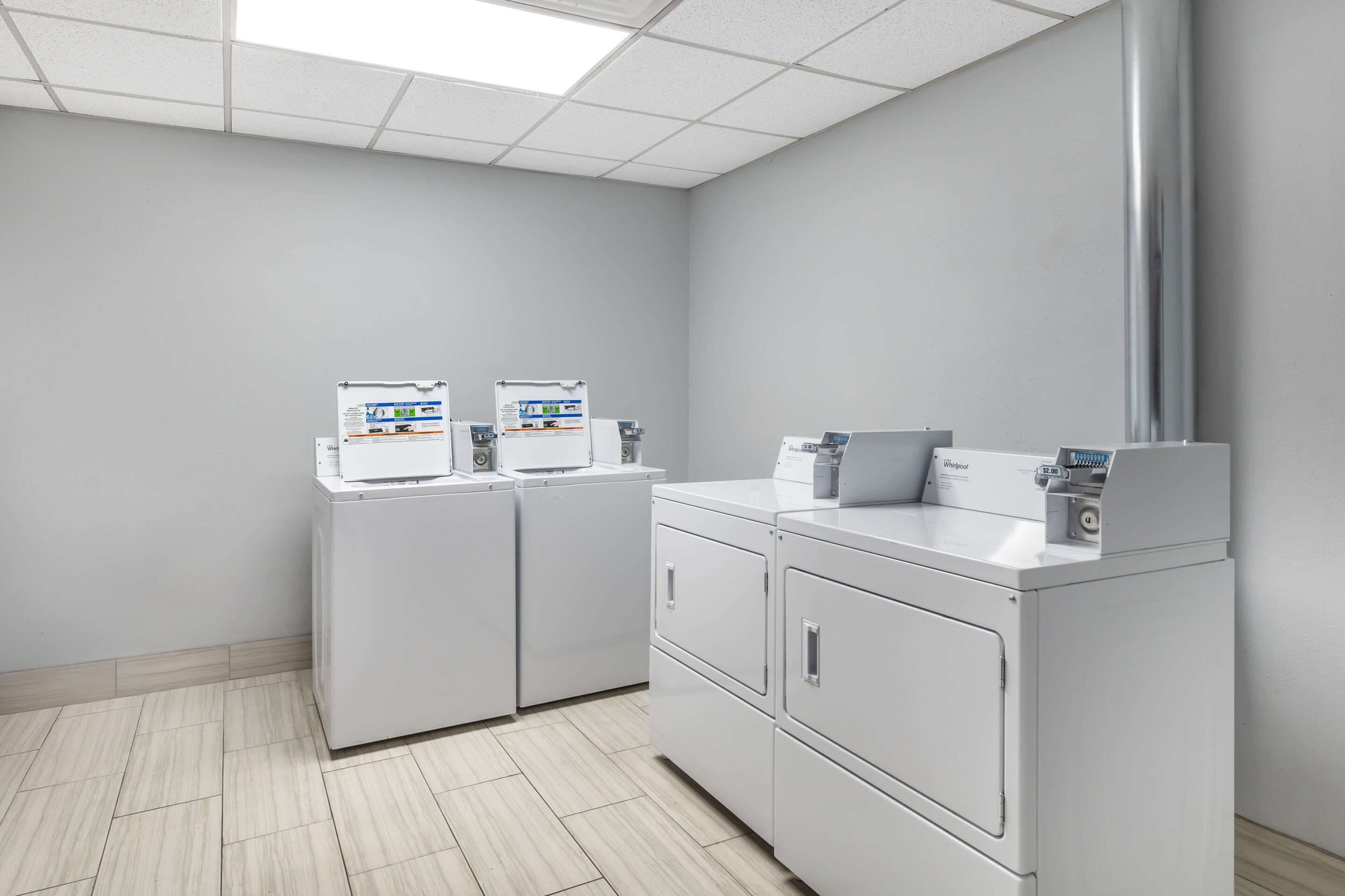 A clinical setting with two washing machines and a large sink.