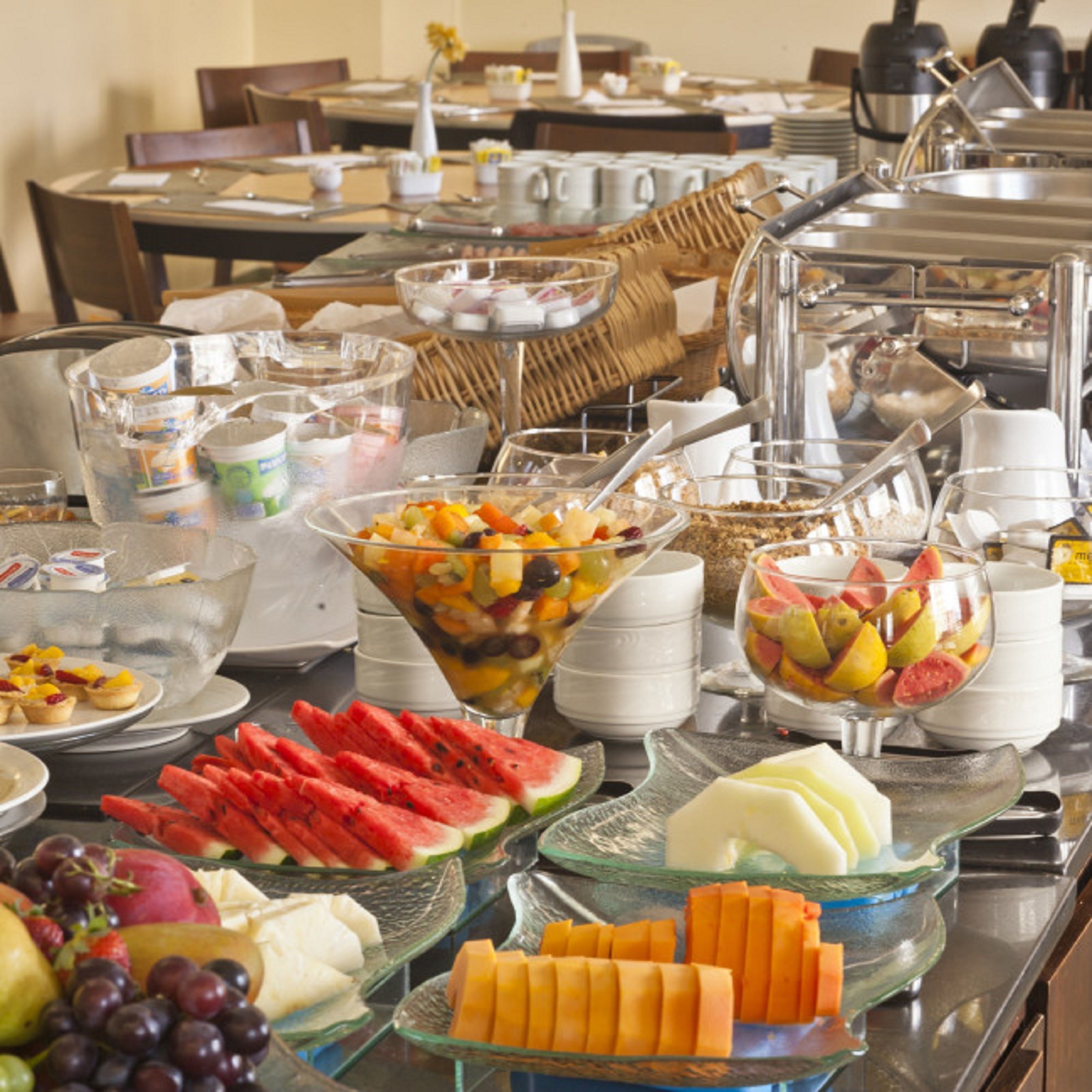 A buffet with various fruits, cheeses, and other food items.
