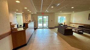 A spacious lobby with a reception desk, seating area, and a clear exit. - Peppermill Empress Inn (Centralia)