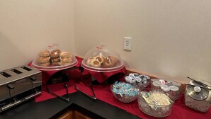 A buffet setup with covered food items and various containers of condiments and snacks. - Peppermill Empress Inn (Centralia)