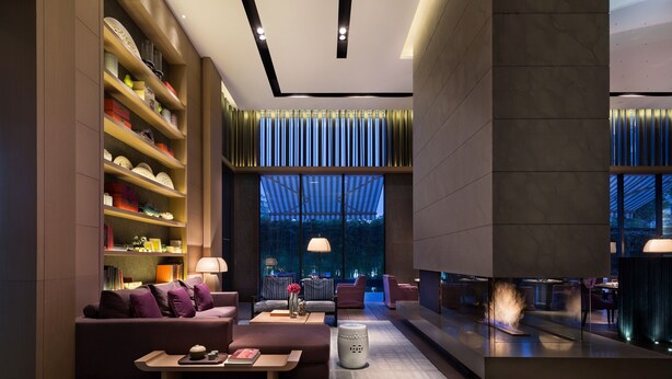 Een modern interieur met een bank, bijzettafeltje en boekenkasten.
