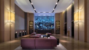 Een modern interieur met een grote flatscreen-tv, comfortabele zitplaatsen en sfeerverlichting.