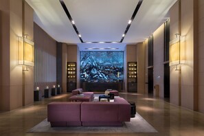 Relax in this stylish living area with a large flat-screen TV, plush sofa, and sleek lighting fixtures.