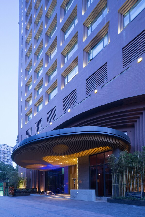 Welcome to the hotel entrance, featuring a curved overhang and vertical windows.