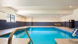 A swimming pool with clear blue water, tiled walls, and a bench by the pool. - Sleep Inn & Suites North Mobile Saraland (Saraland)