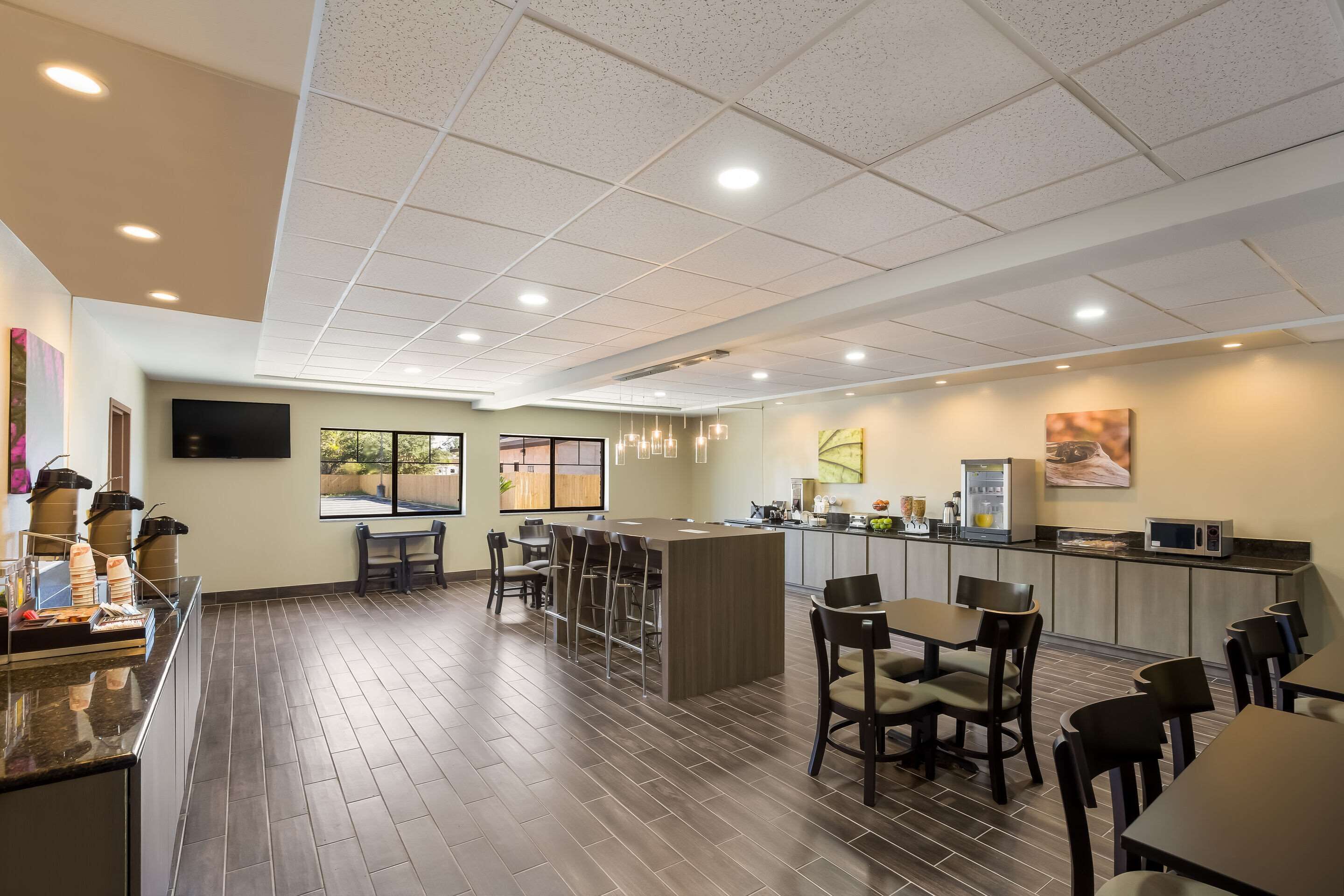 A modern restaurant with a bar area, seating, and a kitchen counter.