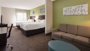 A hotel room with two beds, a desk, a chair, a sofa, and a large window with sheer curtains. - Sleep Inn & Suites North Mobile Saraland (Saraland)