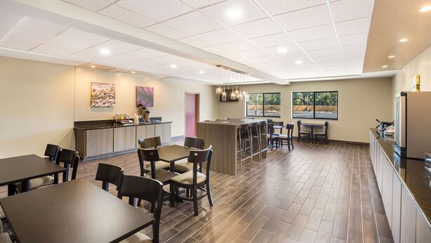 A spacious restaurant with high ceilings, a central bar area, and a view of the outdoors. - Sleep Inn & Suites North Mobile Saraland (Saraland)