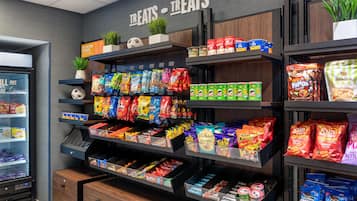 A snack aisle with various packaged snacks and a refrigerated section on the left.