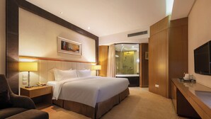 A hotel room with a large bed, a desk with a flat-screen TV, a shower area, and a painting on the wall. - Landison Airport Hotel HangZhou (Hangzhou)