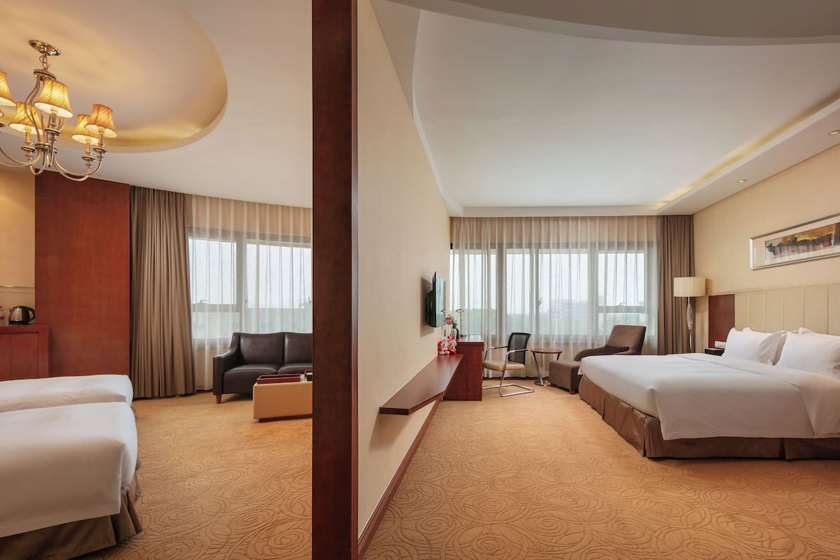 Een hotelkamer met twee bedden, een bank, een bureau en een televisie.