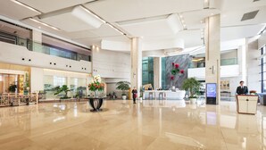A spacious lobby with a reception desk, seating area, and large windows. - Landison Airport Hotel HangZhou (Hangzhou)