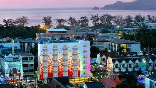 Un hotel con varios pisos, balcones y vista al mar.