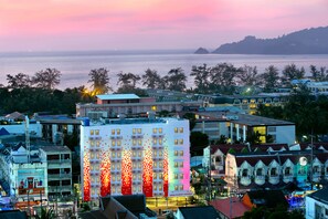A hotel with multiple floors, balconies, and a view of the sea. - Easy Planet Phuket, Patong (Patong)