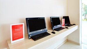 Tres portátiles sobre un escritorio con un cartel a su lado.