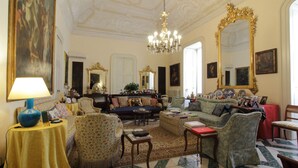 A spacious living room with a chandelier, ornate mirrors, and classic furniture. - B&B Palazzo Bernardini Suite (Lecce)