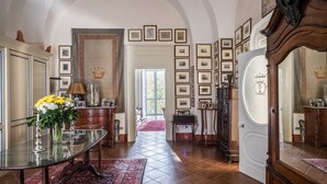 A spacious room with a glass table, a red patterned rug, and a large mirror. - B&B Palazzo Bernardini Suite (Lecce)