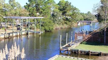 A riverside dock with wooden walkways and a covered seating area.