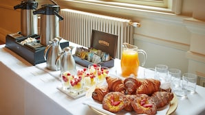 A breakfast buffet with croissants, fruit, and juice. - The Angel Hotel Abergavenny (Abergavenny)